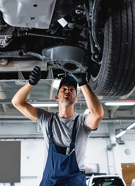 Mechanic examining car undercarriage repair
